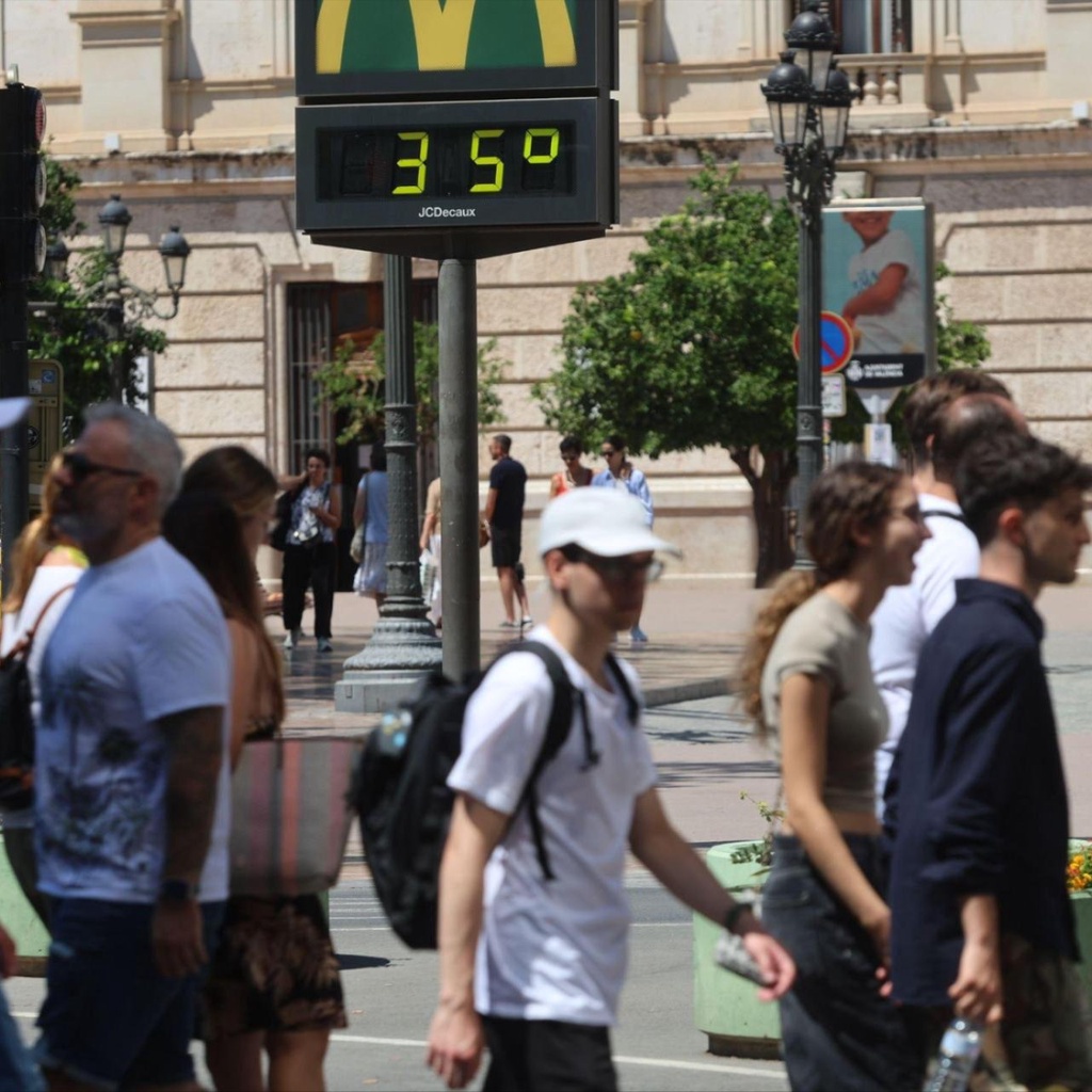 People walking in front of a city thermometer