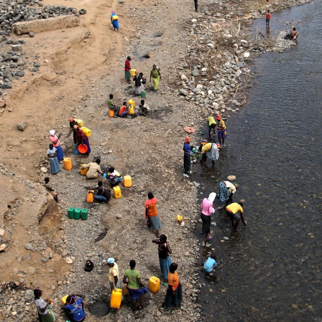 People stand by a river